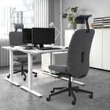 Ufficio minimalista con sedie VALLFJÄLLET, doppio monitor, grandi finestre.