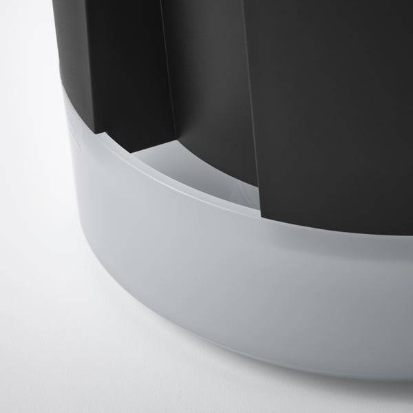Moderna seduta circolare nera con elegante base curva bianca.