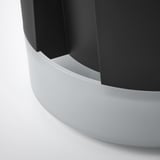 Moderna seduta circolare nera con elegante base curva bianca.
