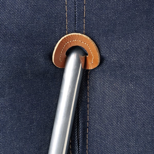 Primo piano del dettaglio della sedia letto in denim ben realizzato. Cuciture resistenti e accenti in pelle che mostrano una costruzione di qualità.