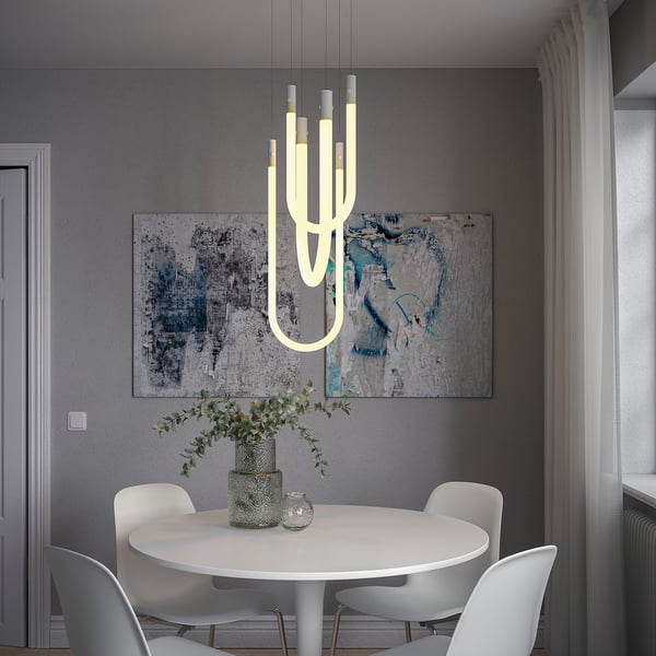Sala da pranzo moderna con lampada VARMBLIXT, tavolo bianco e piante.