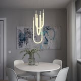 Sala da pranzo moderna con lampada VARMBLIXT, tavolo bianco e piante.