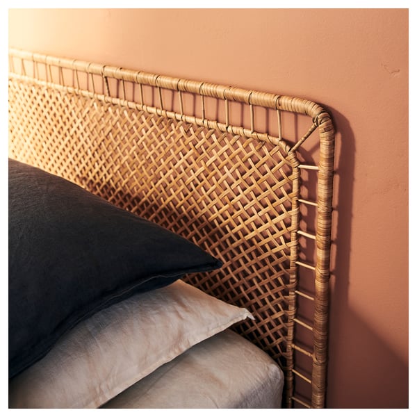 Letto VEVELSTAD con testiera in rattan, trama incrociata, contro parete arancione.