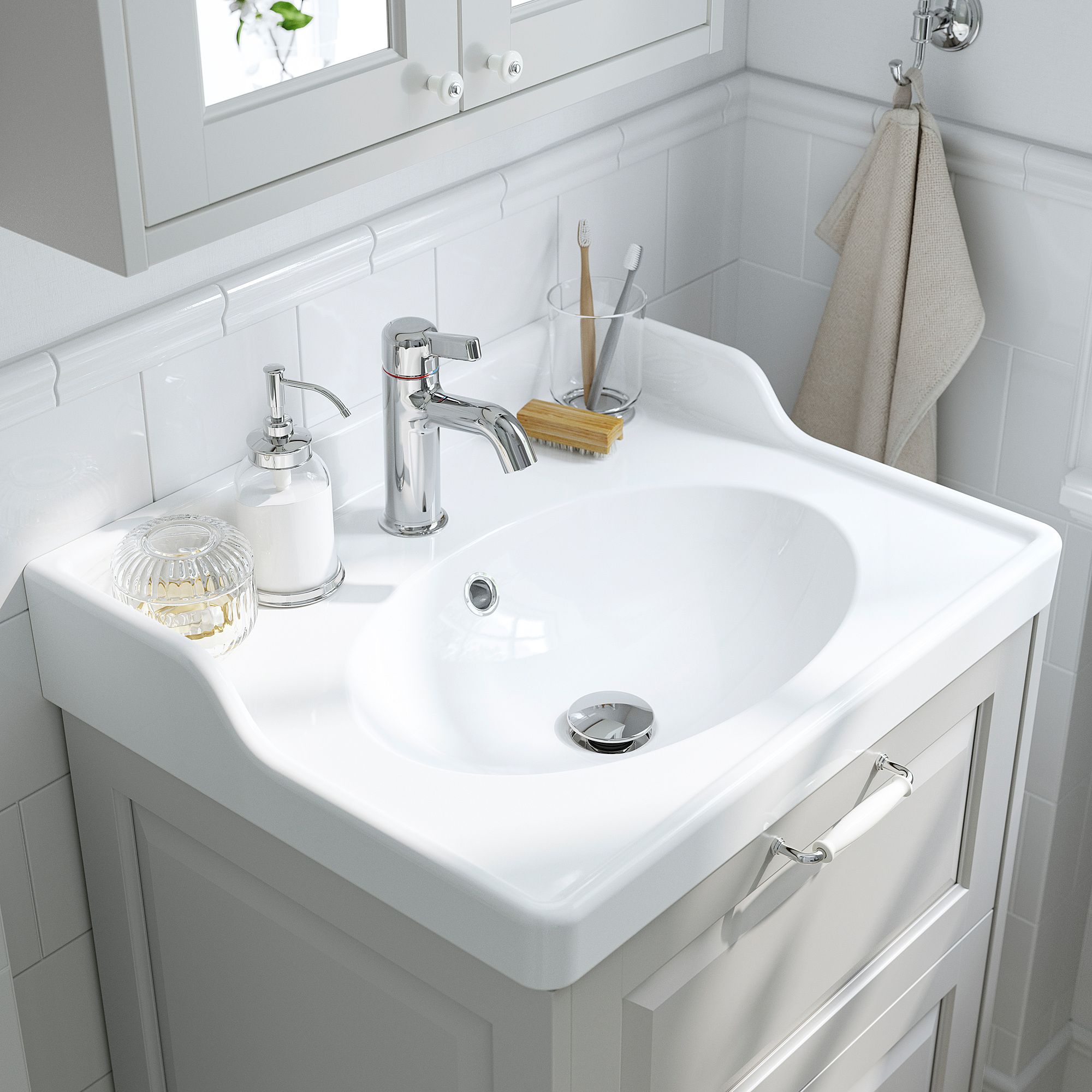Lavabo bagno bianco con sanitari cromati, rubinetto VOXNAN, dispenser sapone, porta spazzolino.