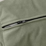 Primo piano della cerniera del divano letto verde chiaro, evidenziando il tessuto liscio e la cerniera di qualità.