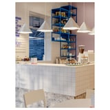 Caffetteria moderna con luci ZEBRASÄV, scaffali blu e pasticcini.