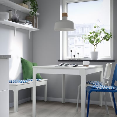 Modern dining area with white ÄNGSFRÄKEN chair pads in green and blue, adding comfort and colour to minimalist decor.