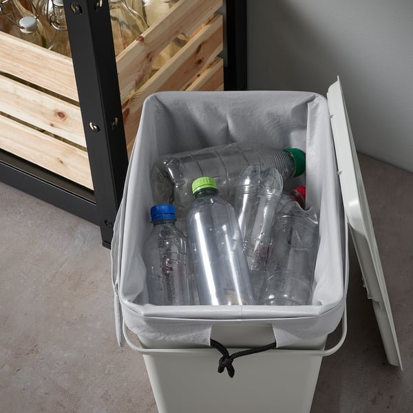 White recycling bin with clear plastic bottles inside, suitable for dry waste sorting.