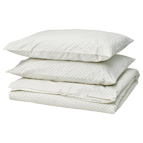 Three white cotton pillows with green woven patterns stacked neatly; soft, square shapes, simple and elegant design.