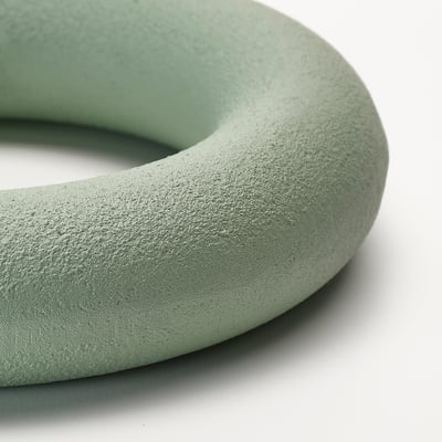 Close-up of green, smooth, round fitness weight, highlighted texture and surface.