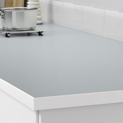 Kitchen countertop, grey with white trim. Spill-proof, easy to clean. Suitable for cutting and covering edges.