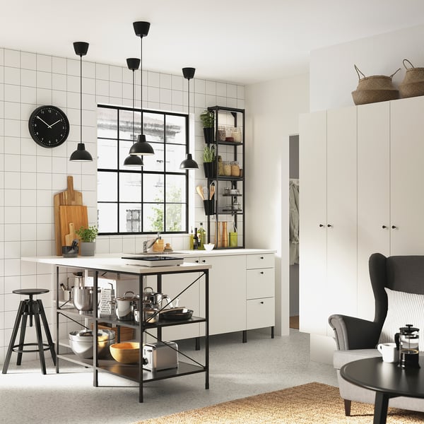 Modern kitchen featuring white cabinets, black fixtures, stainless steel appliances, hanging lights, and a wooden island.