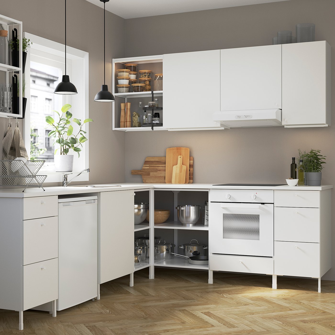 Modern white kitchen with ENHET cabinets, sink, dishwasher, oven, plants, and open storage.