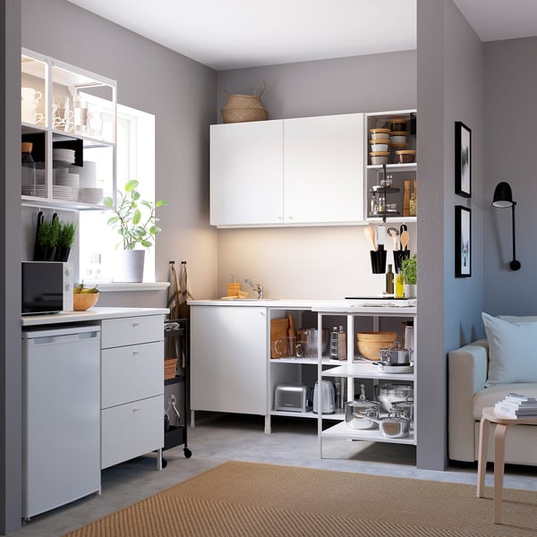 Modern compact kitchen: white cabinets, stainless steel appliances, grey walls, wooden accents, practical layout.
