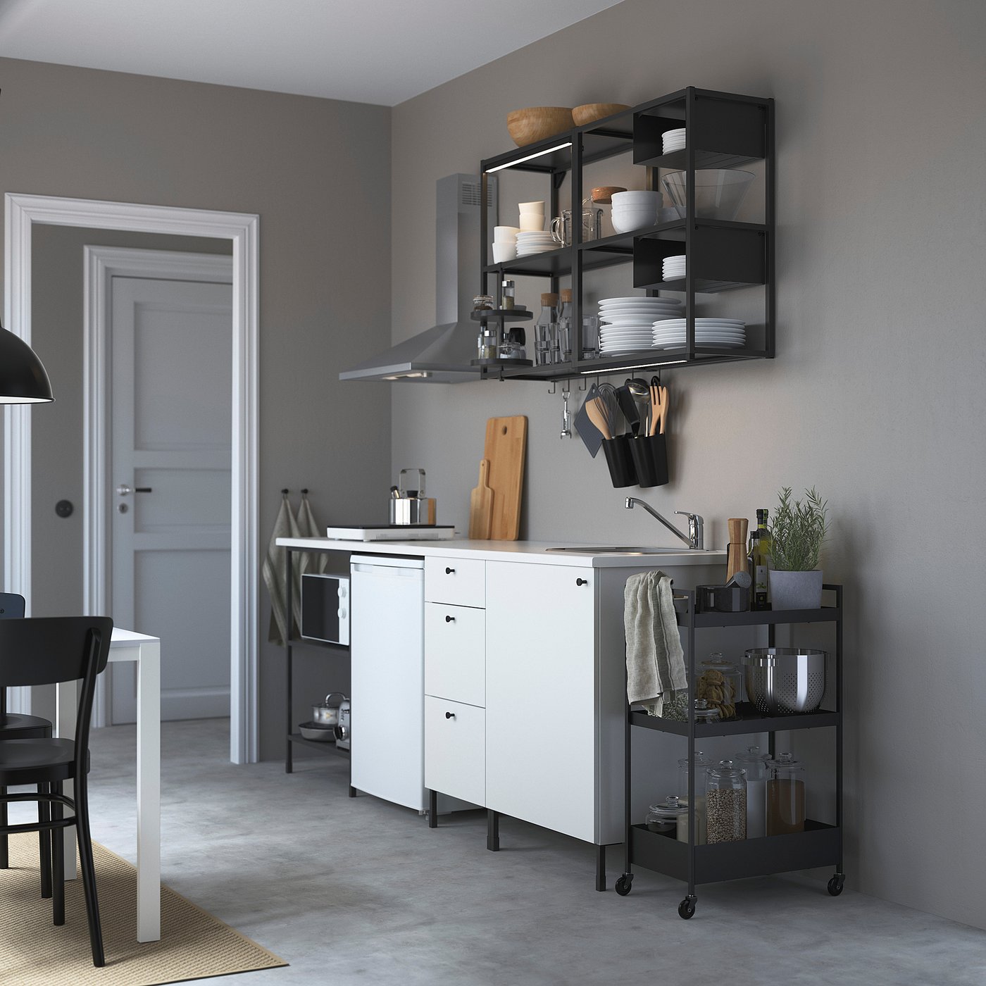 Modern kitchen with ENHET series, white cabinets, stainless sink, wooden boards, hanging utensils, mobile cart, and open shelves.