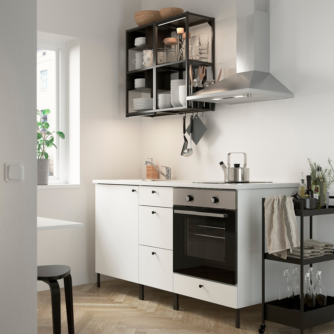 Modern compact white kitchen with ENHET series, integrated oven/sink, open shelves, and stainless steel accents.