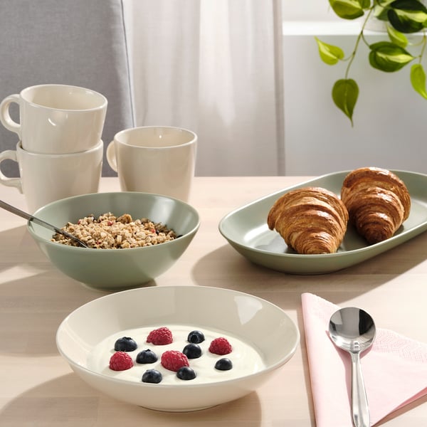 Breakfast setup: cereal, yoghurt, croissants & coffee by window.