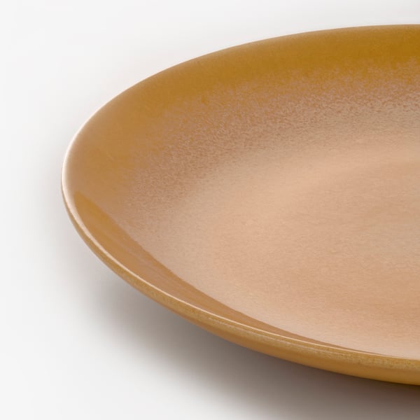 Close-up of a single, smooth, and glossy side plate with a warm orange hue, showcasing its fine texture and elegant curves.