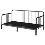 A FYRESDAL day-bed in black. It a metal frame with vertical bars, a sleek design, and can transform into a sofa or double bed.