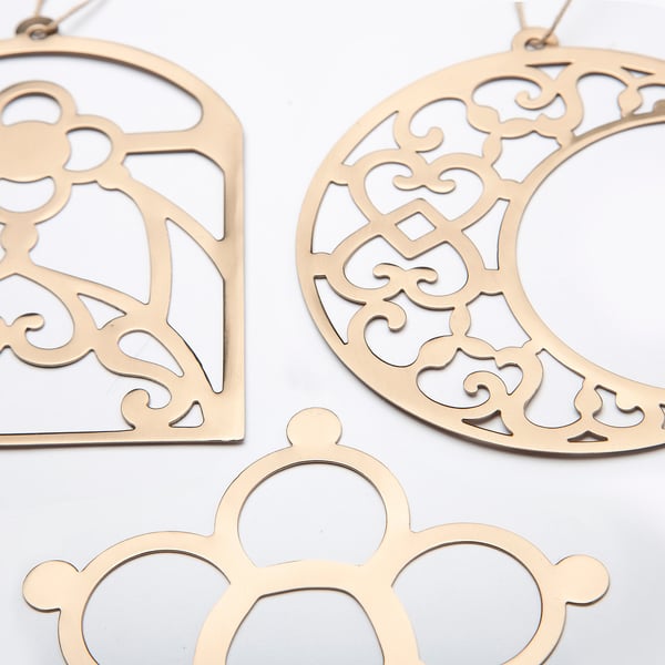 Gold-colored metal ornaments with intricate designs. Decorative patterns; ready to hang.