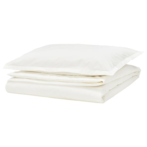 Stack of white bedlinen: folded duvet cover and pillowcase with decorative border, crisp cotton percale.