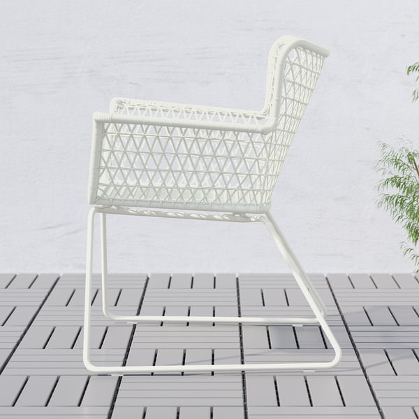 White outdoor chair with woven seat and back, ideal for gardens or balconies, offering comfort with armrests and flexible rattan.
