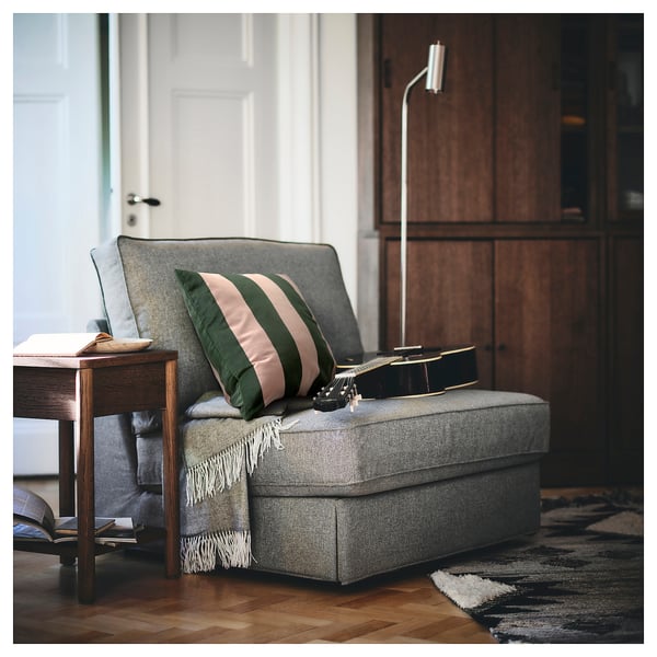 Powerpoint slide with grey IDGRAN cushion, green and pink stripes, on a bench beside a wooden table with guitar and books.
