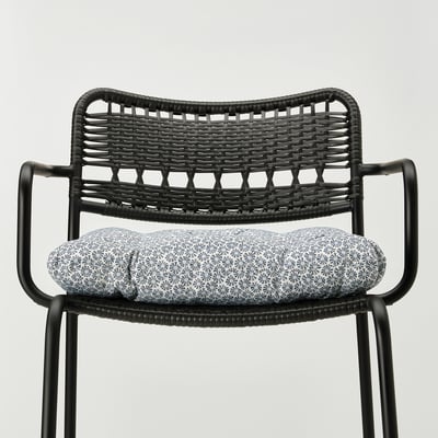 Black woven chair with patterned seat cushion, ties secure cushion.