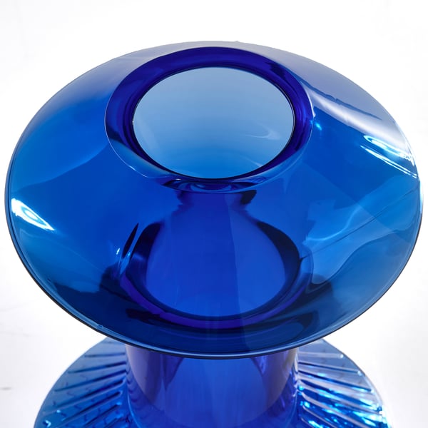 Blue glass vase, smooth and polished, with wide opening and slightly curved design.
