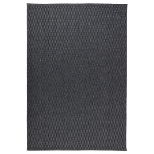 A dark grey MORUM rug. Its flat-woven, rectangular, and made of 100% polypropylene. Suitable for both indoor and outdoor use in moderate climates.