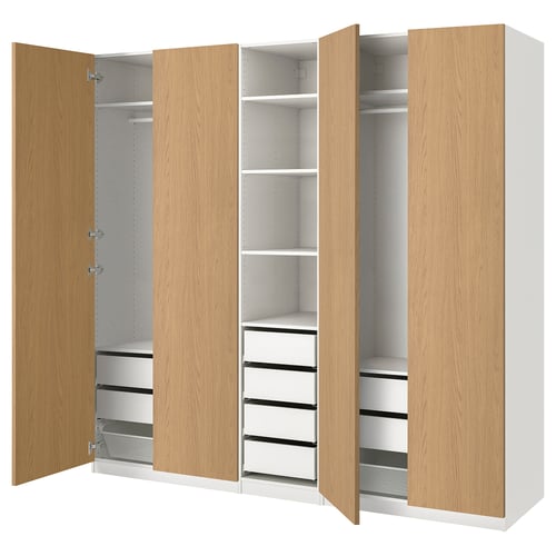 A light wooden PAX wardrobe with multiple shelves and drawers, offering versatile storage.