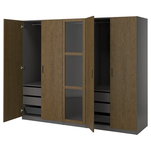 An open PAX wardrobe with brown woodgrain doors, black interior, shelves, drawers, and mesh baskets.