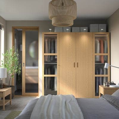 Modern bedroom with large PAX wardrobe, grey accents, bamboo lamp.