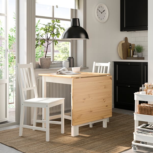 PINNTORP folding table in cosy kitchen with chairs, lamp, cabinet, and trolley.