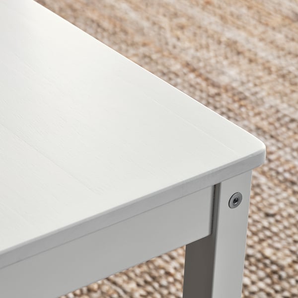 Close-up of white wooden table edge, smooth finish, clean design, sturdy construction.