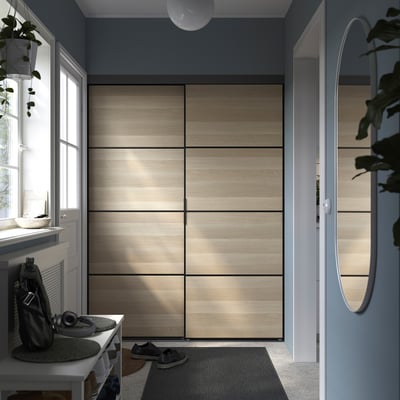 Modern bedroom with SKYTTA closet. Dark blue walls, entryway setup.