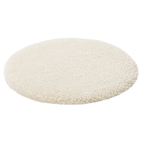 Circular white sheepskin rug, plush and soft.