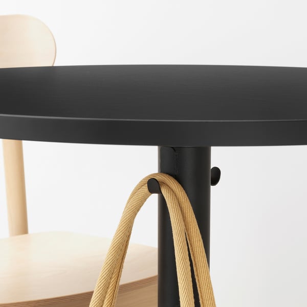 Black table with beige ropes hanging, likely for storage or decoration.