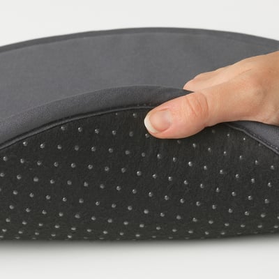 Hand pressing thin, round chair pad with dots for comfort and grip.