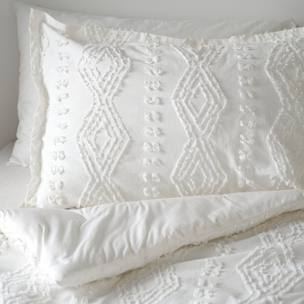 White bedding set with textured chenille diamonds, soft cotton, inviting; machine washable.