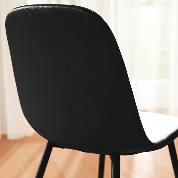 Black chair back, upholstered in quality fabric, with smooth, supportive curves.