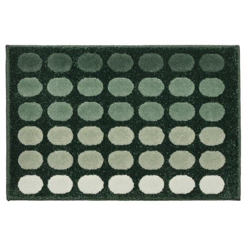 A dark green TUNNELBANA mat with a circular gradient pattern, made of polypropylene, rectangular and textured.