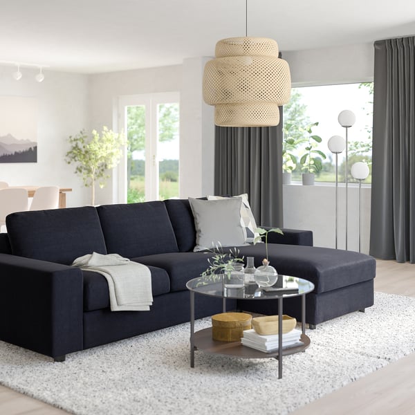 VIMLE modern black sofa, l-shaped with storage, fits well in spacious living rooms, accented by woven pendant lamp, grey curtains, and white rug.