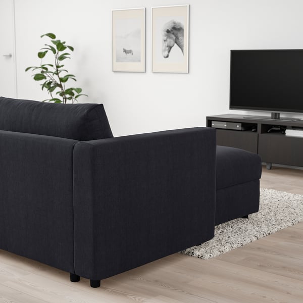 Modern living room with black l-shaped VIMLE sectional sofa facing tv, plant left.