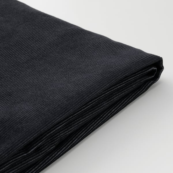 Black corduroy fabric close-up, showing texture and stitching, clean and well-maintained.
