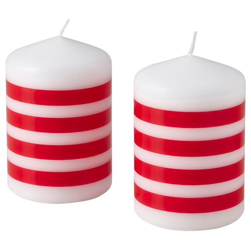 Two red and white striped candles, standing upright, cylindrical shape, cotton wicks, made of paraffin and plant-based wax.