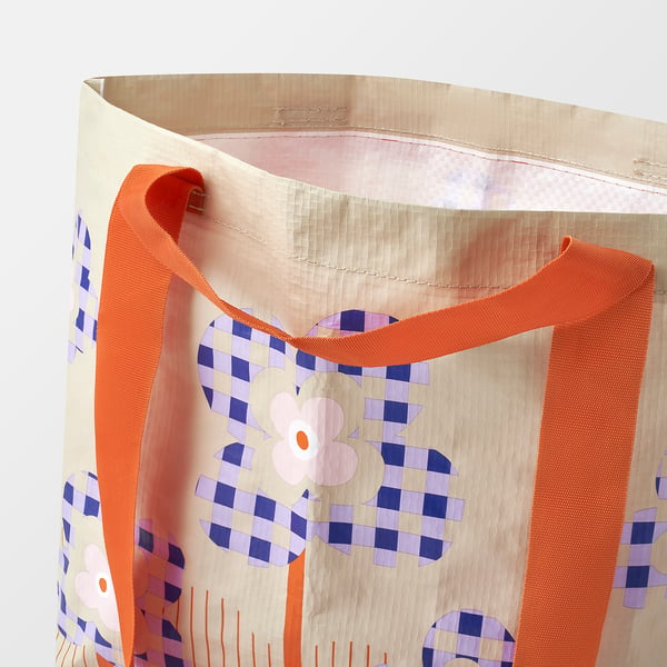 Stylish tote bag with floral design, durable orange handles, recycled materials.
