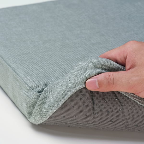 Close-up of soft, grey ÅKERVINDEFLY chair pad, showcasing memory foam comfort and non-slip material.