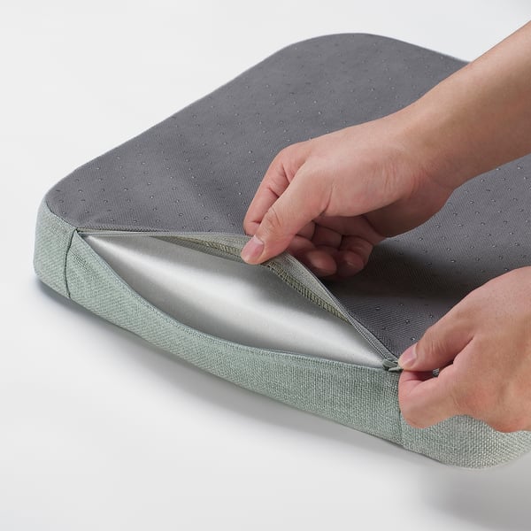 Person opening a grey chair pad with memory foam.
