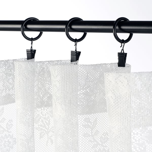 Black curtain rod with three sheer white curtains, clamped by black clips for a tailored look.